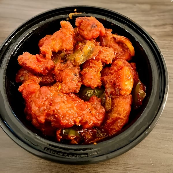 Hershey Spice Restaurant & Bar's vibrant red Indian chicken dish with green peppers in a black bowl.